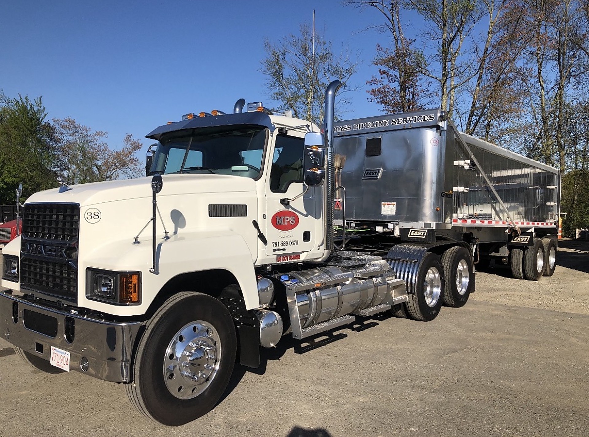 Mass Pipeline Services dump truck and end-dump trailer parked in the yard
